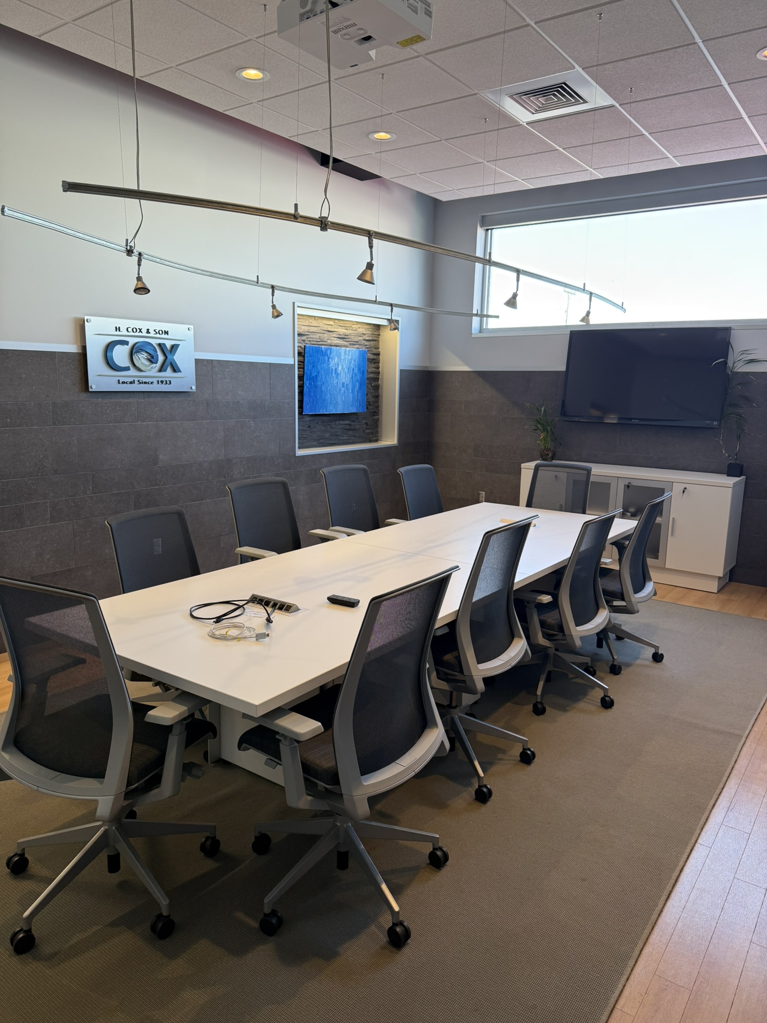 Boardroom with H. Cox & Son sign and presentation display