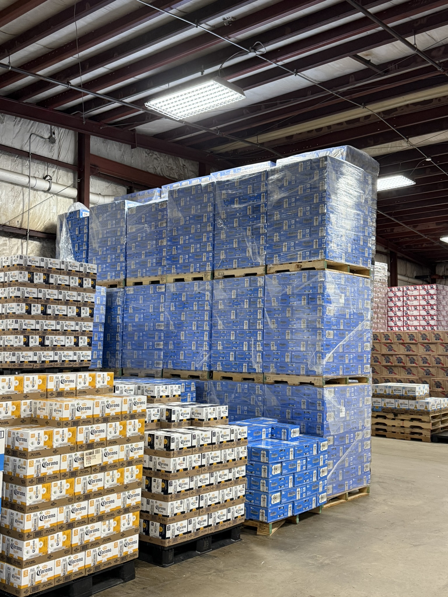 Pallets of Corona, Corona Light, and Modelo stacked in the warehouse